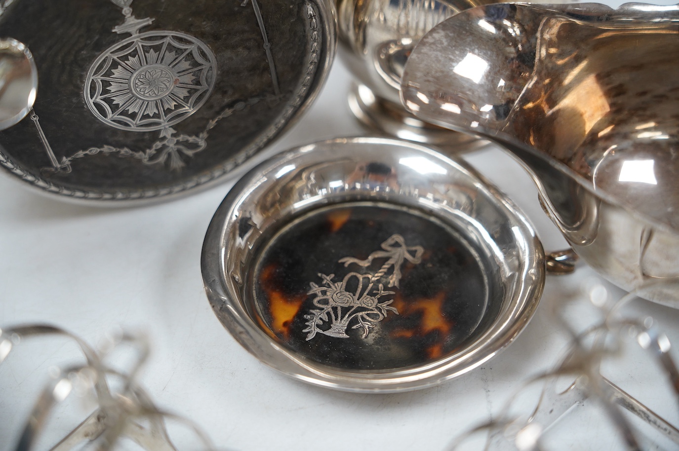 Sundry small silver including a pair of toast racks, Sheffield, 1936, three cream jugs, a sauceboat and two tortoiseshell mounted items. Condition - poor to fair to good